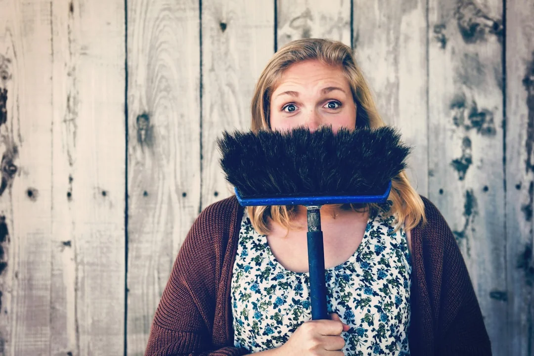 Woman cleaning a bright room with a mop, enjoying music with headphones.